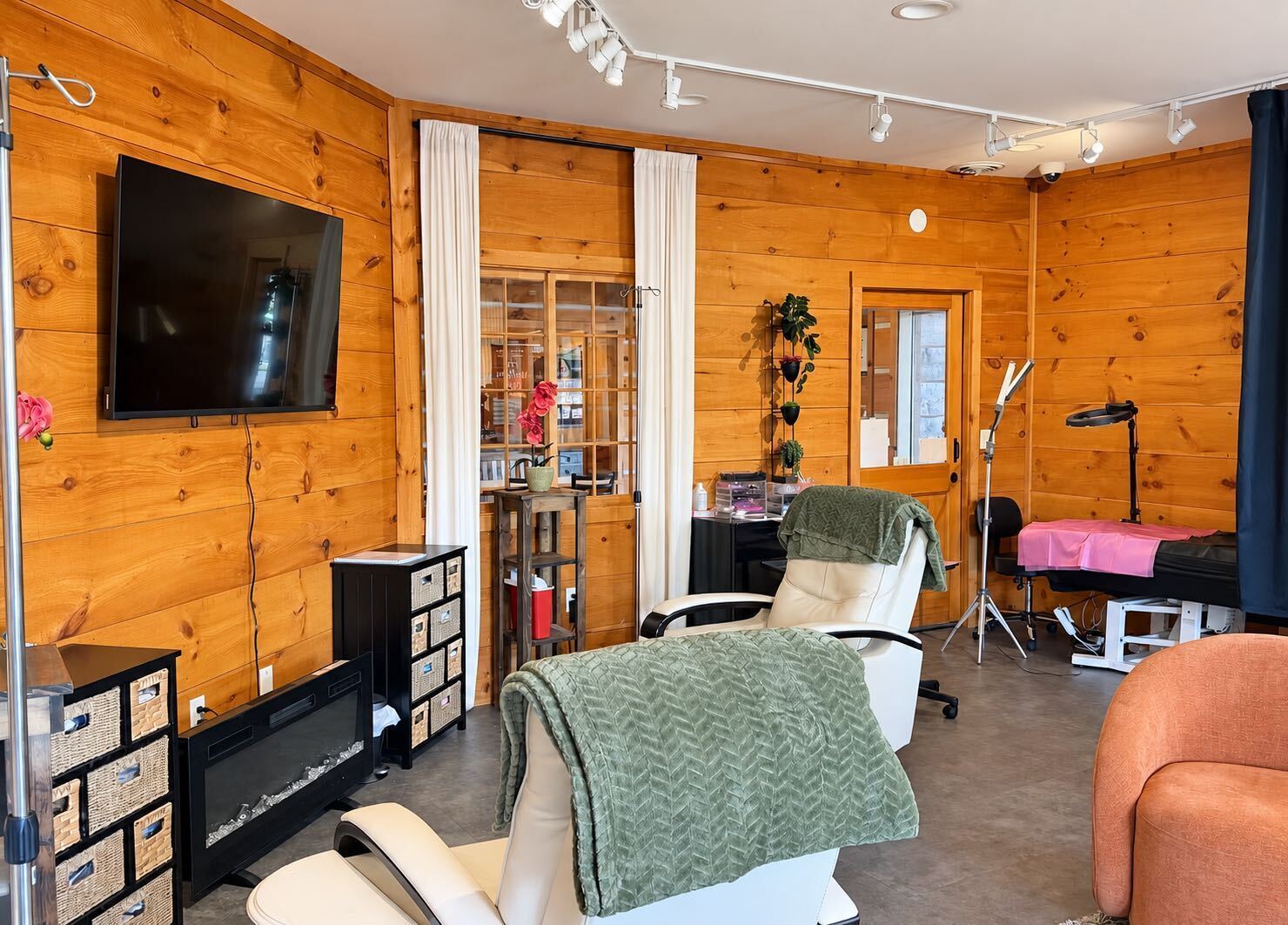 Calm lounge at The Wellness Place with cream recliners, soft blankets and an electric fireplace