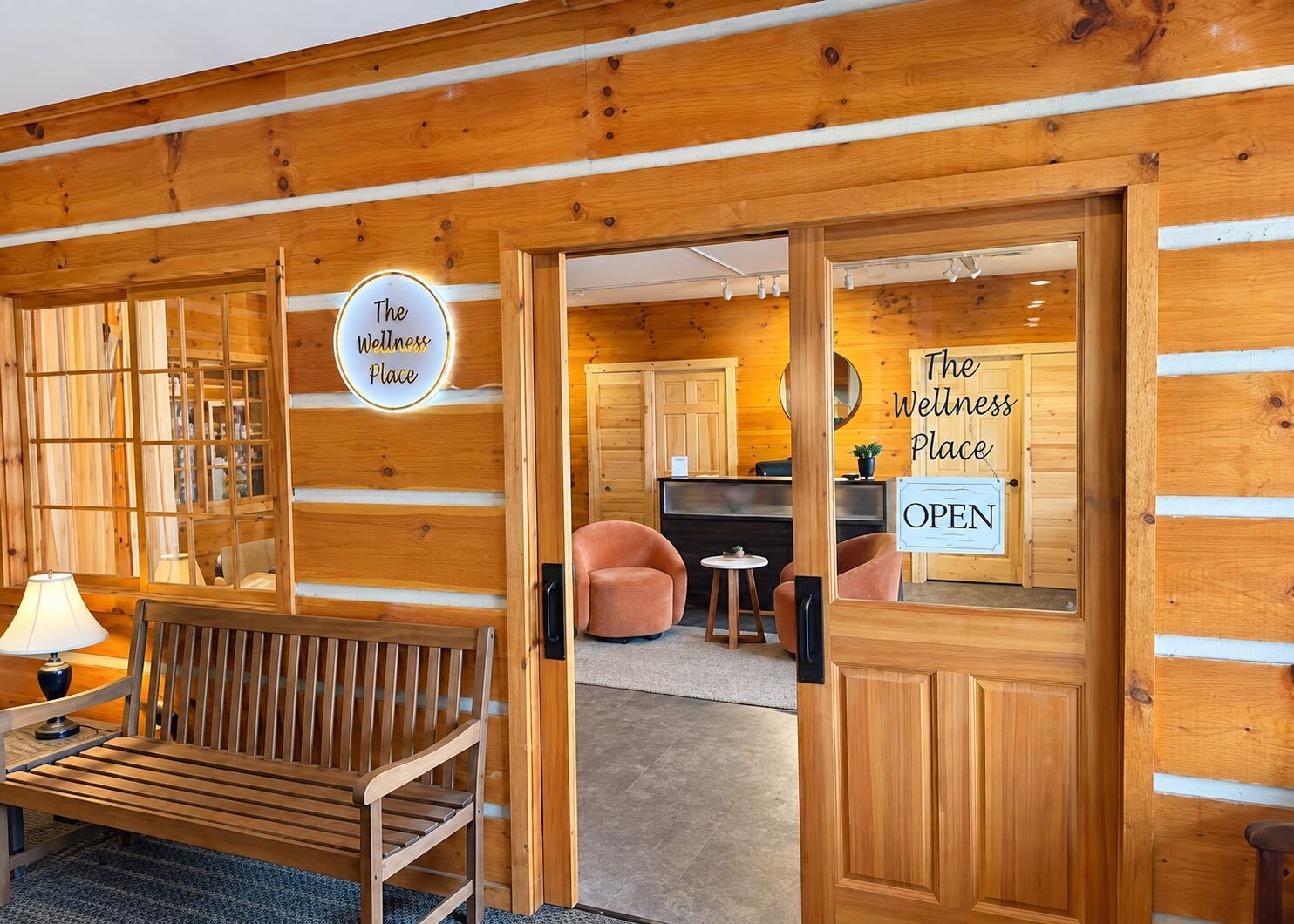 Entrance to The Wellness Place in Siren, with its glowing round sign and open wooden doors